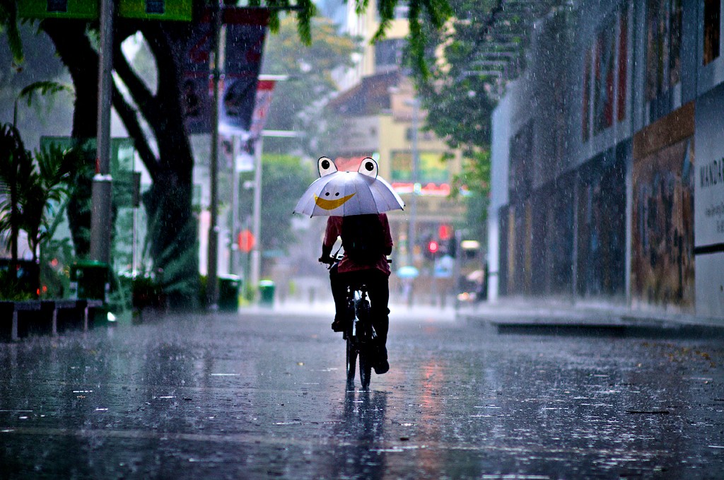 biciklis esőben esernyővel